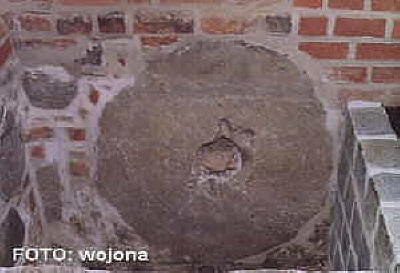 M&uuml;hlstein im Fundament der Kirche. / A millstone at the foundation of the church.